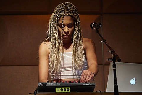 Woman on stage playing a drum machine